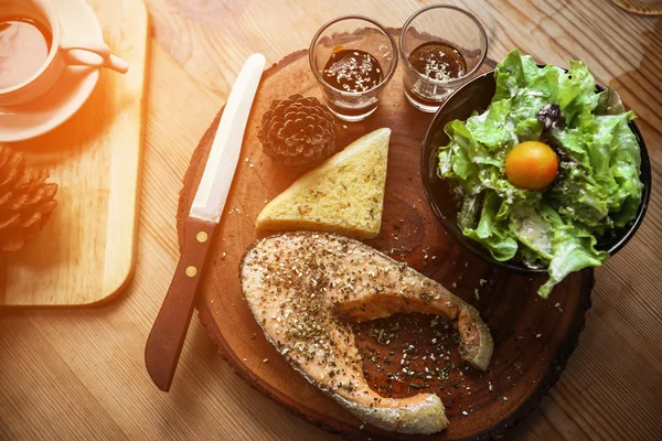 Salmon steak on wooden table in restaurant, Fresh steak for healthy food and clean food or fresh food for diet, International steak on plate with fresh vegetable or salad in the restaurant.