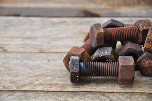 Old bolts or dirty bolts on wooden background, Machine equipment in industry work.