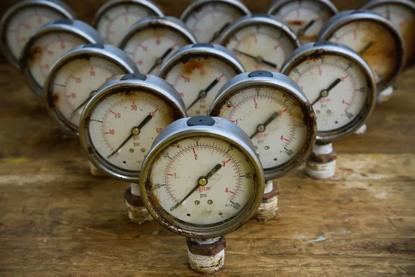 Old pressure gauge or damage pressure gauge of oil and gas industry on wooden background, Equipment of production process.