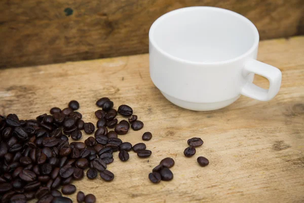 Coffee beans background on wooden, Fresh coffee beans with coffee cup on wooden background, Drinking set background.