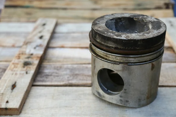 Piston of engine on wooden background, Auto parts industry and spare parts background, piston damage in hard works.