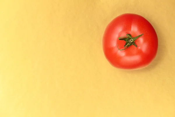 Top view of  red juicy tomato on a gold background