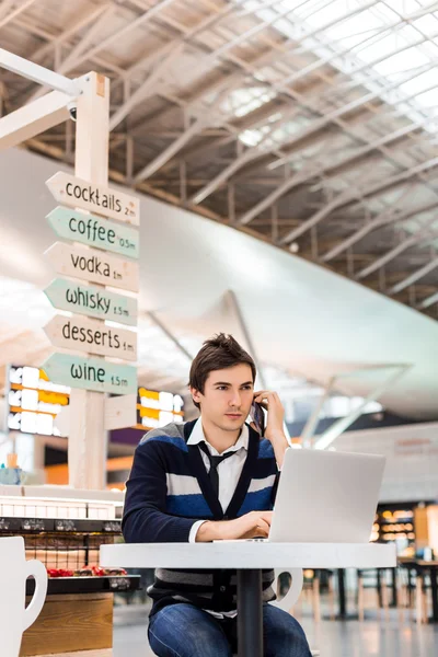 Happy satisfied young man working on laptop