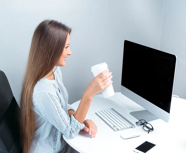 Business woman drinking coffee in office