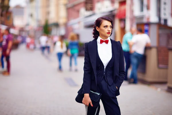 Beautiful elegant woman posing on crowded city street