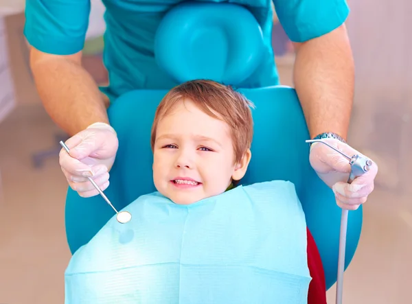 Little kid, patient afraid of dentist while visiting dental clinic