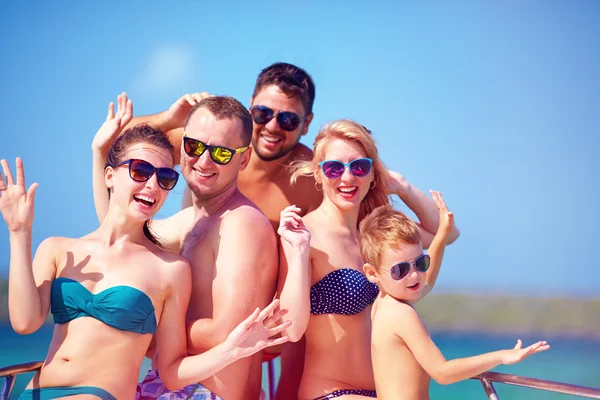 Group of happy friends, family having fun on yacht, during summer vacation