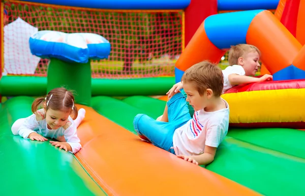 Happy kids having fun on inflatable attraction playground