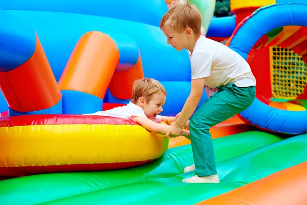 Excited kids having fun on inflatable attraction playground