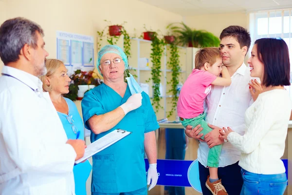 Exhausted medical staff announcing good news to relatives after long and difficult surgery