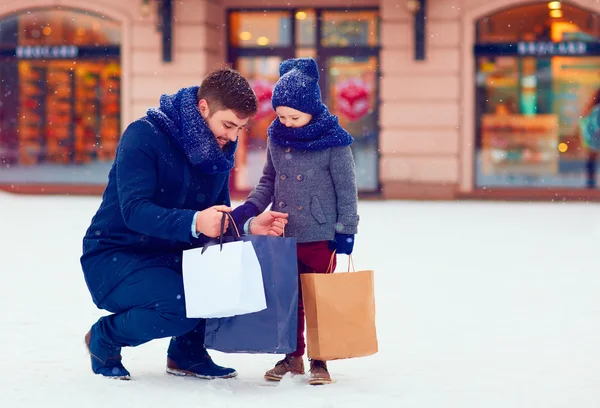 Father and son on winter shopping in city, holiday season