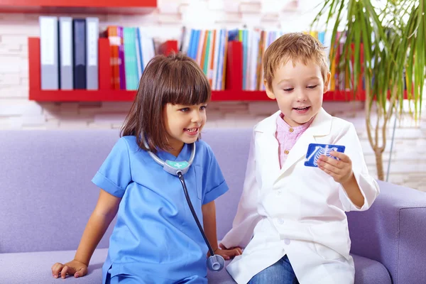 Cute kids playing doctors in office