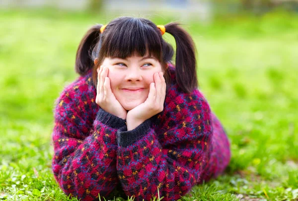Happy young girl with disability on spring lawn