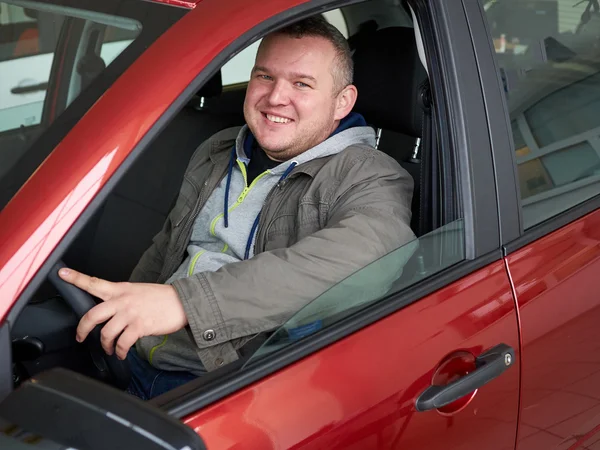 Young fat man behind wheel