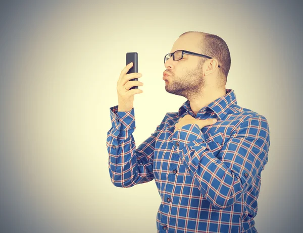 Caucasian man doing a selfie with a kiss.