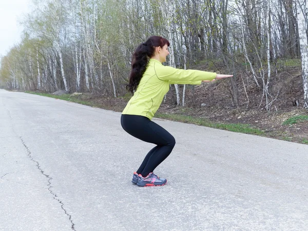 Young woman squat outdoors in nature