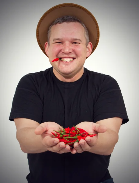 Young fat man with chili in his hands.
