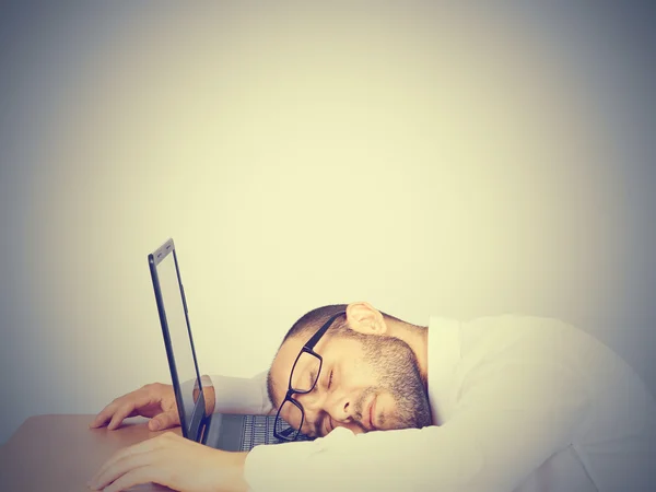 Portrait  of tired businessman sleeping on his laptop