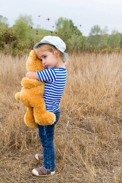 Cute little girl hugging a big Teddy bear