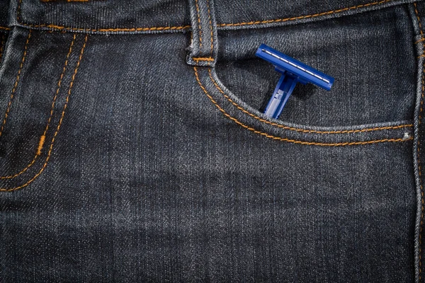 Blue disposable razor in his pocket jeans. background.