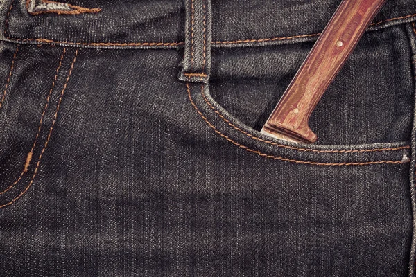 Old knife with a wooden handle in your pocket jeans.