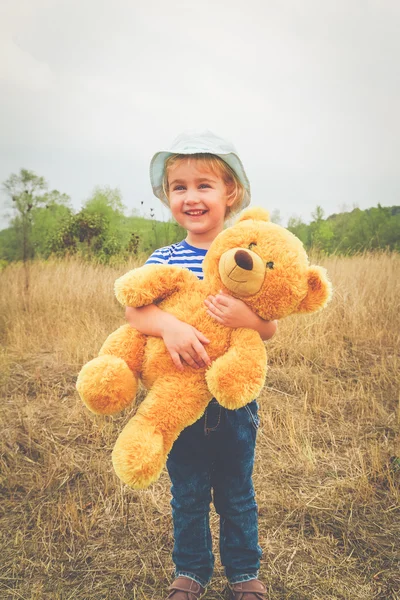 Cute little girl hugging a big Teddy bear