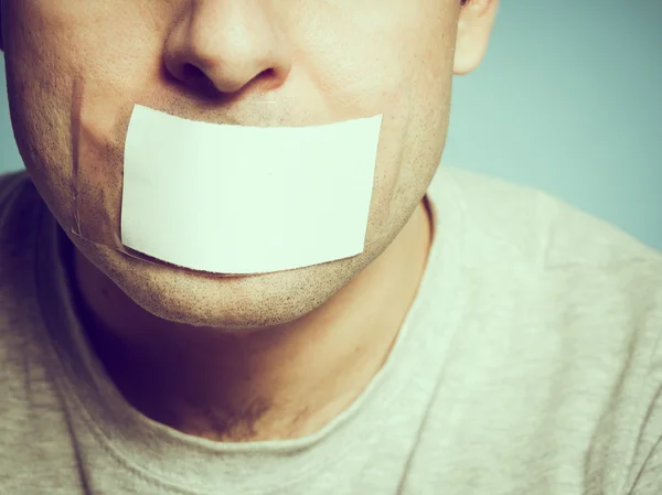 Caucasian man with duct tape on mouth, white .