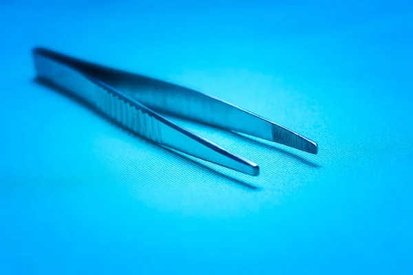 Scratched, worn surgical forceps in an operating theatre