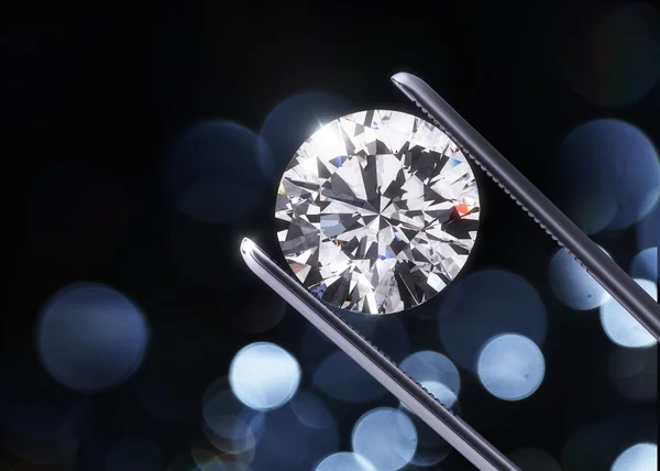 Luxury diamond in tweezers closeup