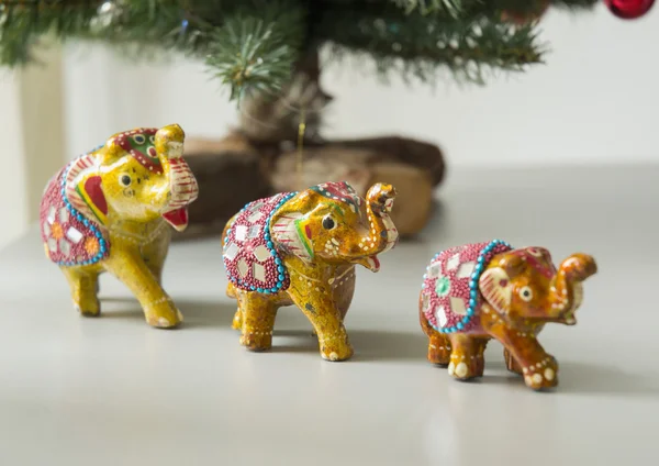 Three toy elephants under Christmas tree