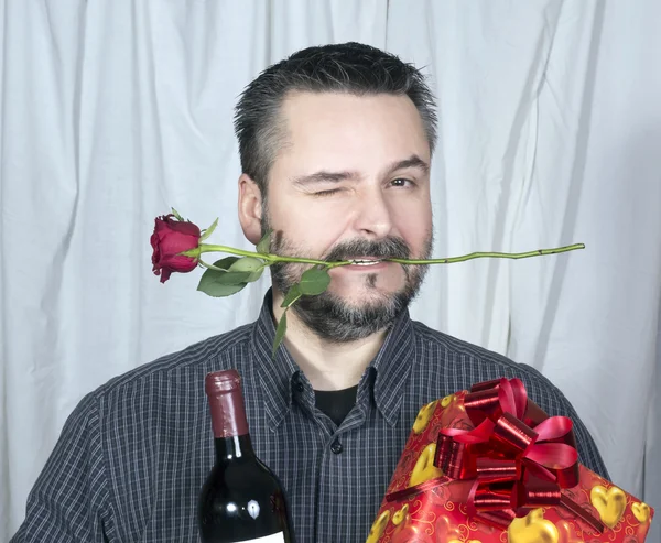 Male winking holding rose in mouth