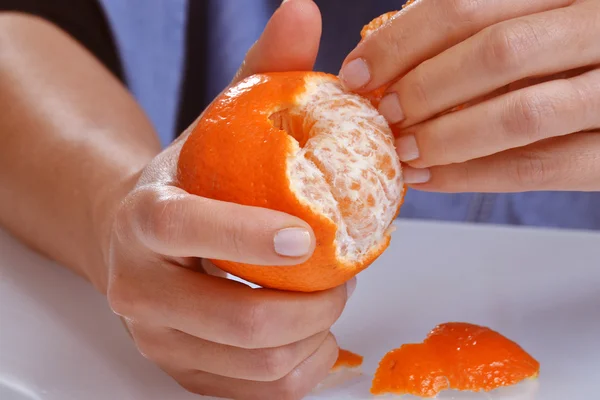Woman  peeling tangerine fruit.