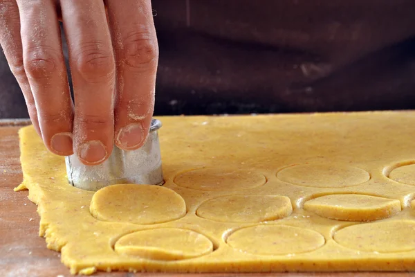 Cook preparing cookies dough using mold