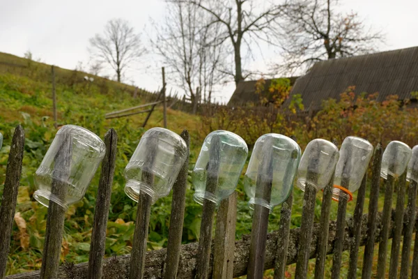 Glass jars hanging on a fence in a village