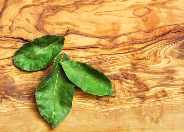 Green bay leaf on wooden texture