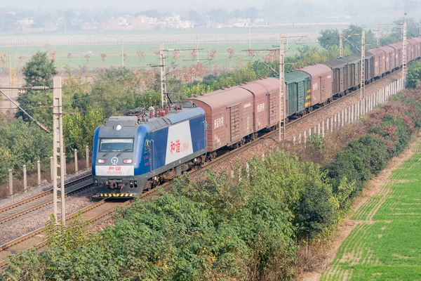 HENAN, CHINA - NOV 16 2014: China Railways HXD3 electric locomotive in Luoyang, Henan, China. The locomotive is designed for hauling 5000t freight trains.