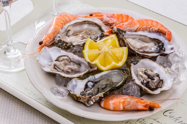 Oysters shell, jumbo shrimp with lemon on ice