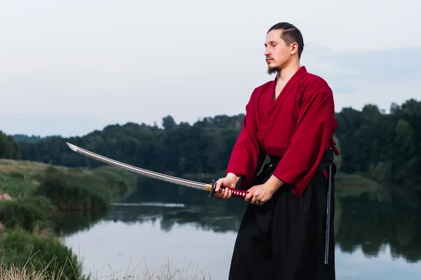 Man in ethnic samurai japanese clothing uniform with katana sword
