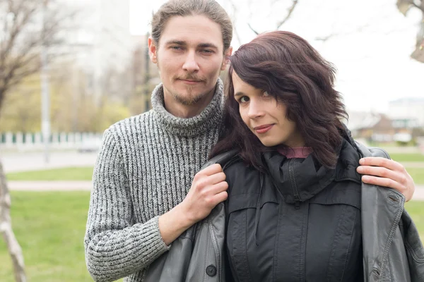 Close up portrait of attractive young couple standing outdoors.