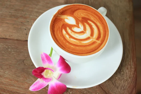Vintage latte art coffee and pink orchid