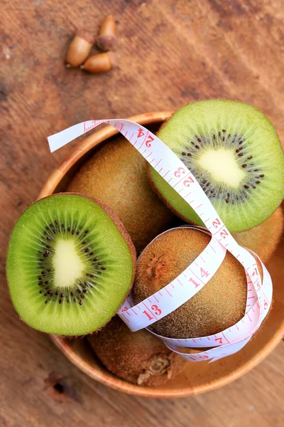 Fresh kiwi fruit and tape measure
