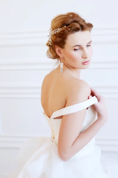 Bridal hairstyle and makeup. Young woman wearing headpiece.