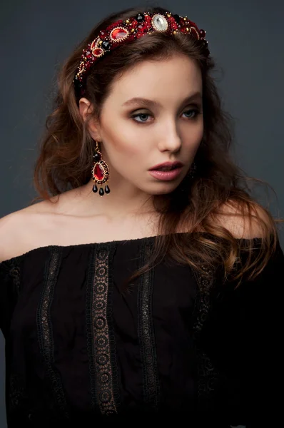 Passionate woman with long wavy hair dressed in black