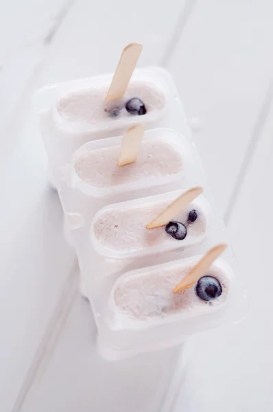 Ice popsicles with yogurt and blueberries in ice lolly mold