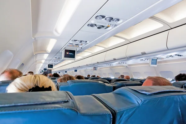 Interior of airplane with passengers on seats during flight