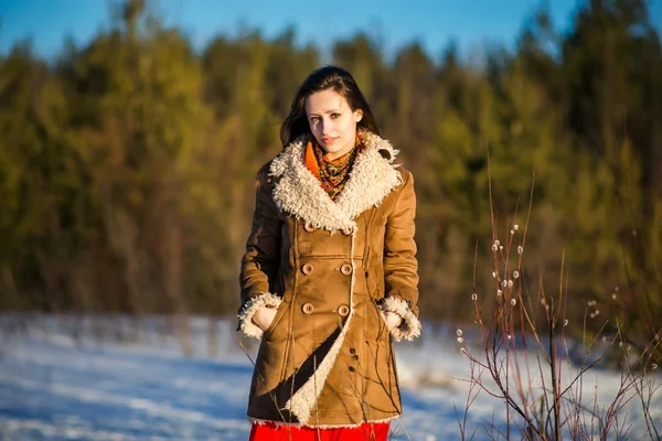 Young beautiful woman in national ukraine suite at snowy winter
