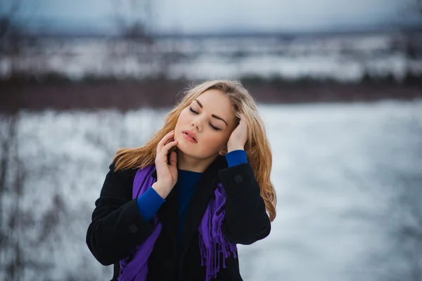 Beautiful sexy face of an young woman with fresh health skin. Female posing in the winter Model stroking her face.