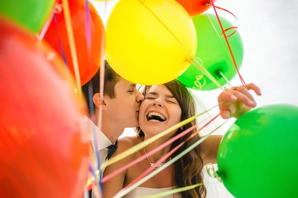 Love, wedding, summer, dating and people concept - smiling couple with balloons hugging and looking to each other in city