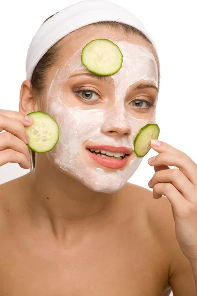 Woman applying cucumber on face