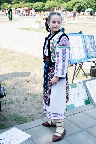 Girl dressed in traditional clothing, posing for a portrait